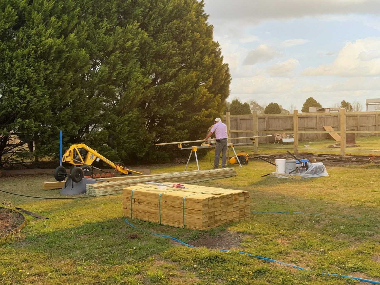 Lively Fence Company crew measuring and cutting lumber while building a new fence